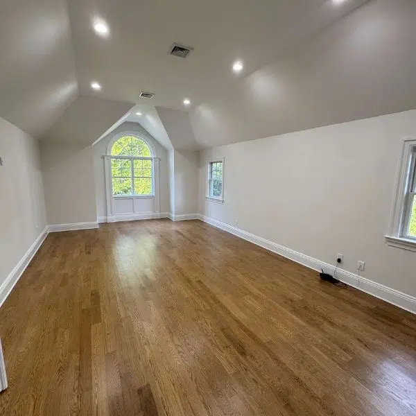 Empty bedroom with light walls and wood floors